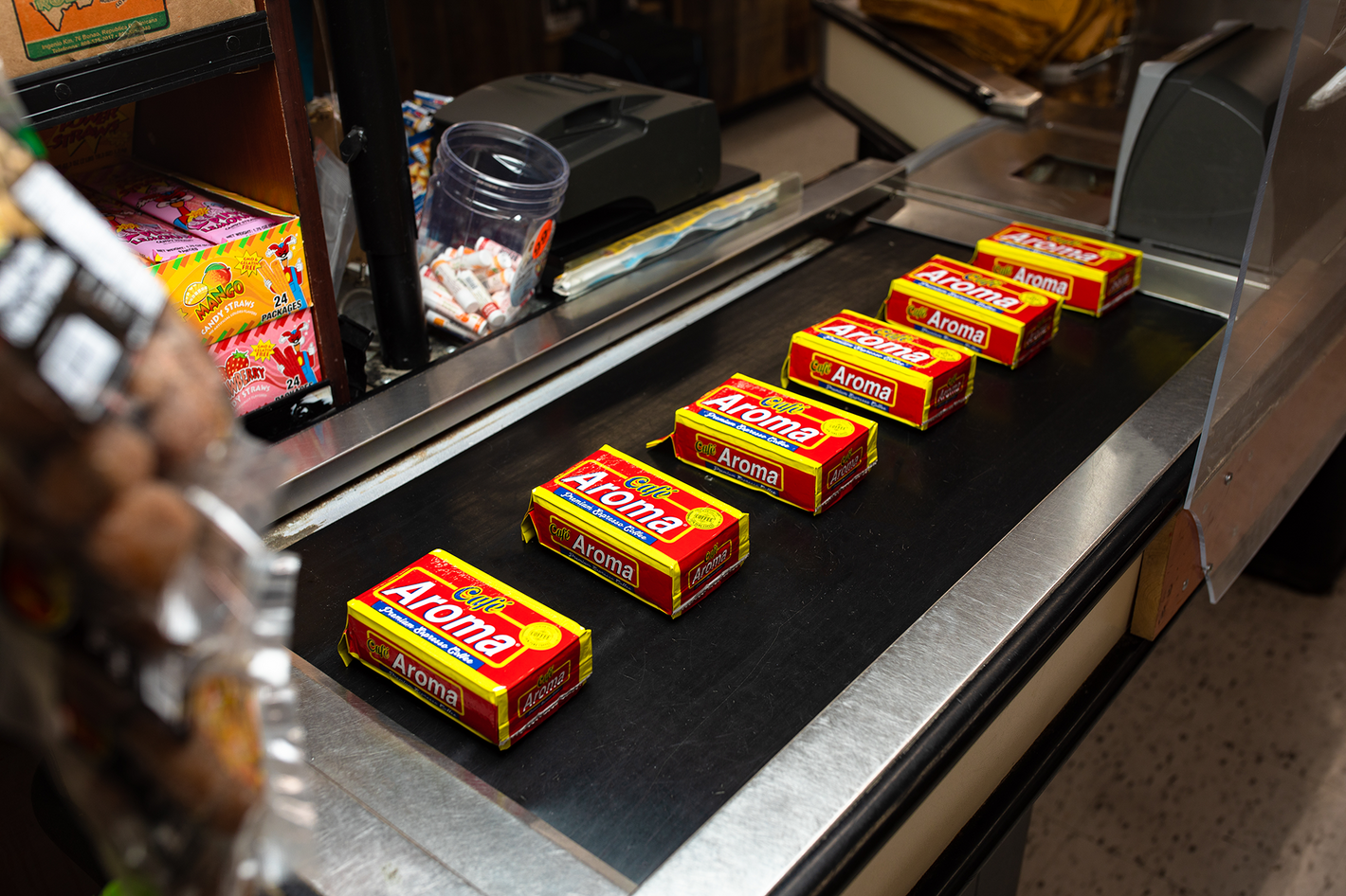 Cafe Aroma coffee blocks on conveyor belt in grocery store 